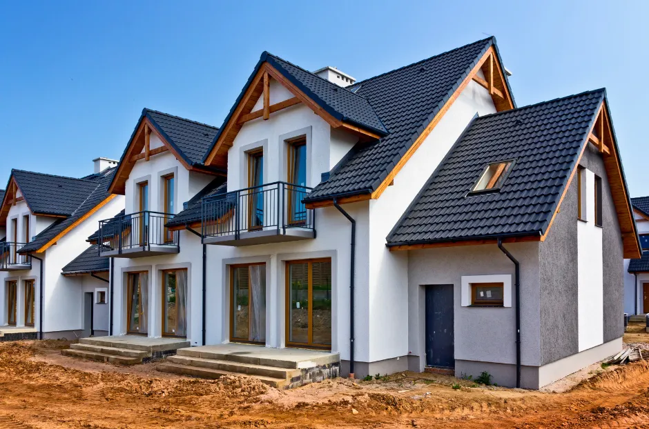 A white house with a black roof is being built